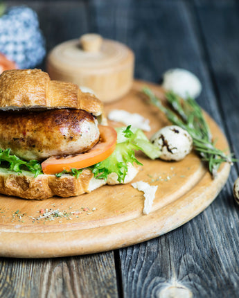 Plate of sausage on bread with tomato and lettuce