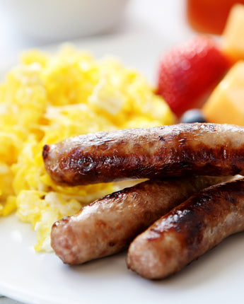 Scrambled eggs, sausage, and fresh fruit