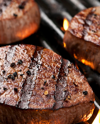 Cooking steaks on the grill with flames