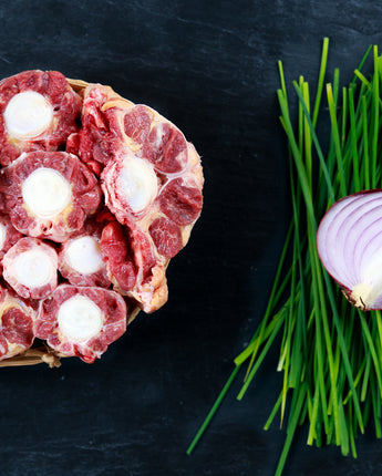 Fresh cuts of rib meat next to onions and garnishes